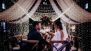 A wedding ceremony with a decorated aisle, chairs, and a floral arrangement. - Centennial Plaza Resort Gulfport (Gulfport)