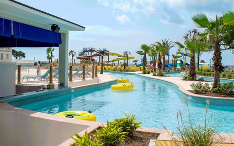 A pool area with multiple water slides and inflatable tubes.