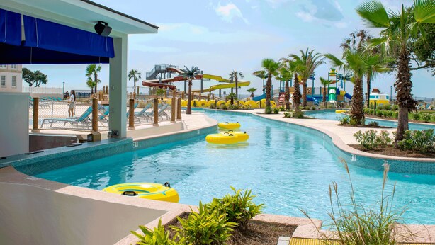 A pool area with multiple water slides and inflatable tubes. - Centennial Plaza Resort Gulfport (Gulfport)