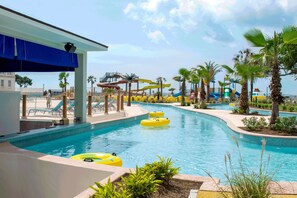 A pool area with multiple water slides and inflatable tubes.