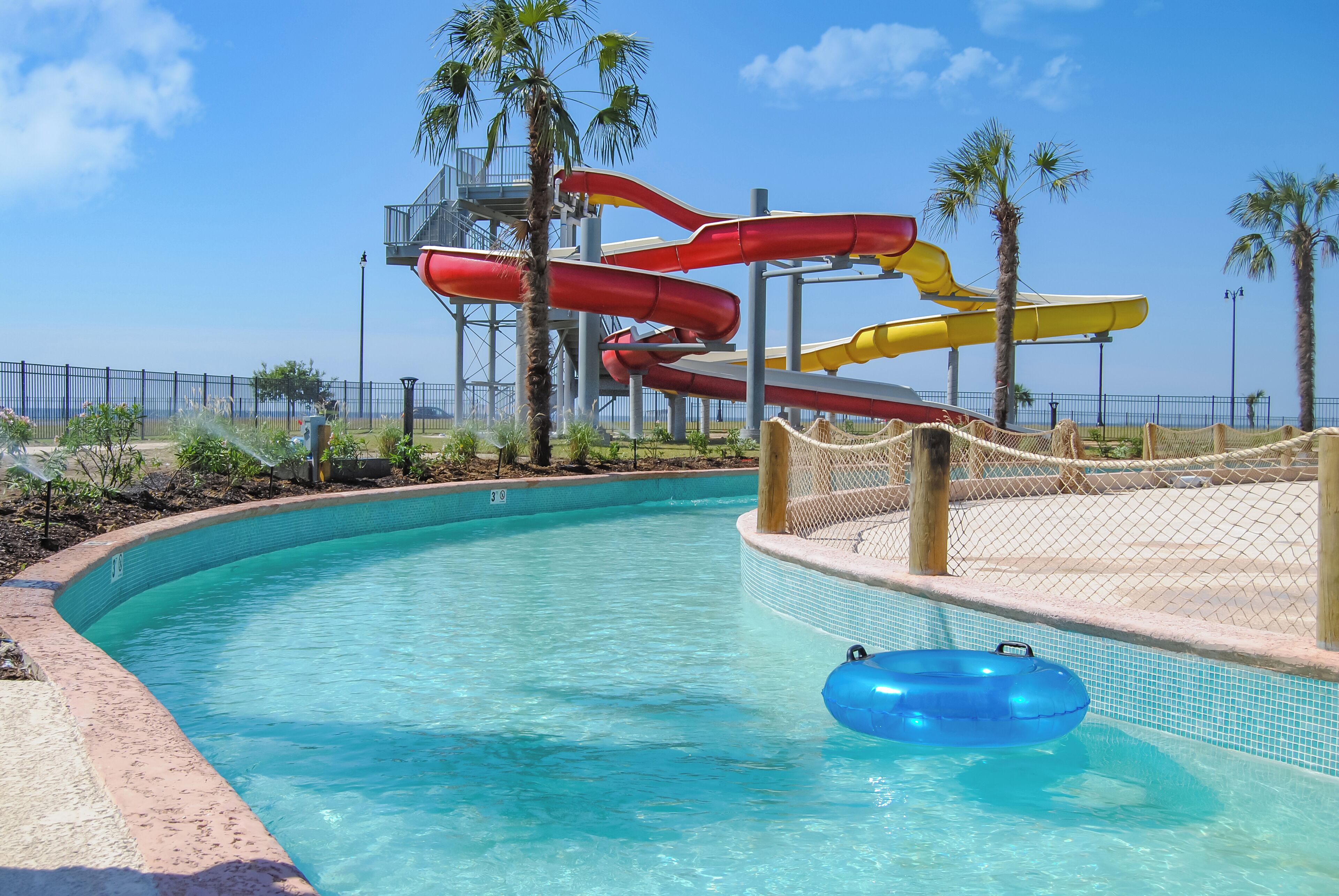 Una piscina con tobogán y un flotador azul.