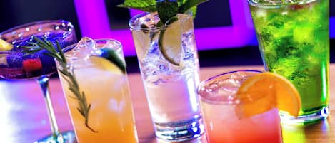 A variety of colorful cocktails on a bar counter.