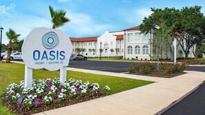 A sign for Oasis Resort in Gulfport, MS, with a well-maintained lawn and flower beds in front. - Centennial Plaza Resort Gulfport (Gulfport)