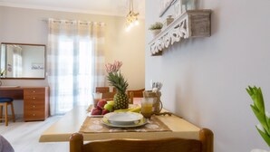 A dining area with a table set for two, a fruit bowl, a pitcher, and a mirror above the table. - Casa Voula (Corfu)