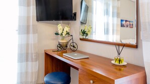 A wooden desk with a laptop, a bicycle-shaped candle holder, and a mirror. - Casa Voula (Corfu)