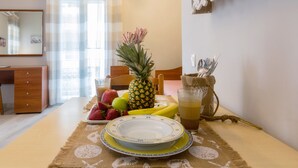 A dining table with fruits, a glass of juice, and a plate. - Casa Voula (Corfu)