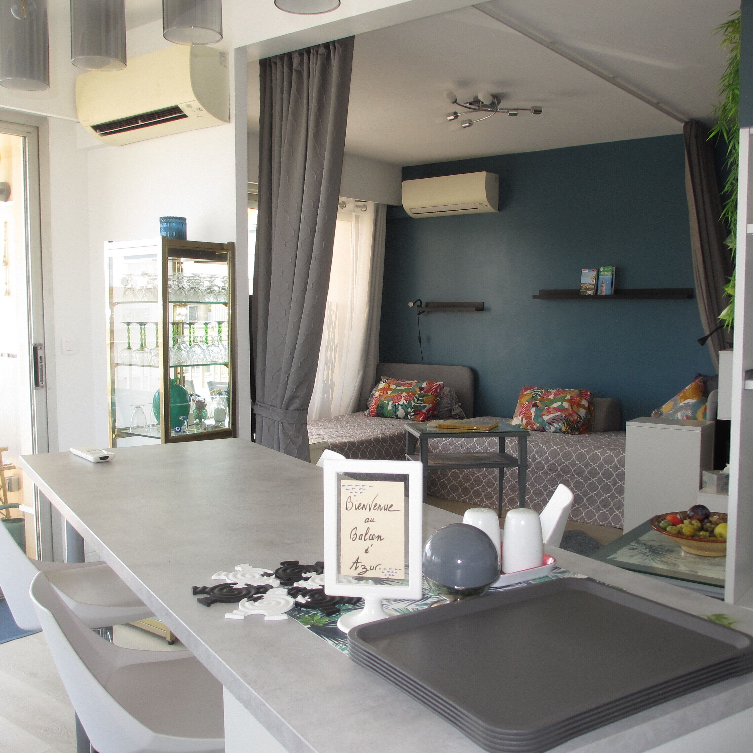A modern living room with a sofa, a coffee table, and a dining area with a tray.