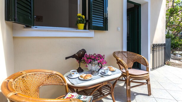 A table set with a coffee pot, cups, pastries, and a newspaper. - Foxy Studio 2 (Corfu)