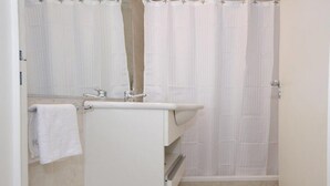 A bathroom with a white sink, mirror, and towel rack. - Velez Sarsfield Apartment AJC (Córdoba)