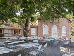 A brick building with large windows and a tiled roof.