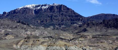 Un paisaje montañoso con un pico nevado destacado.
