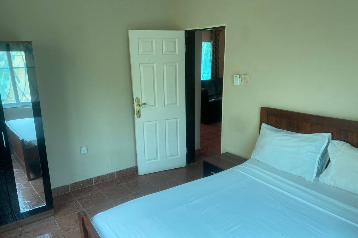 Un dormitorio con cama, una puerta y vistas a otra habitación.