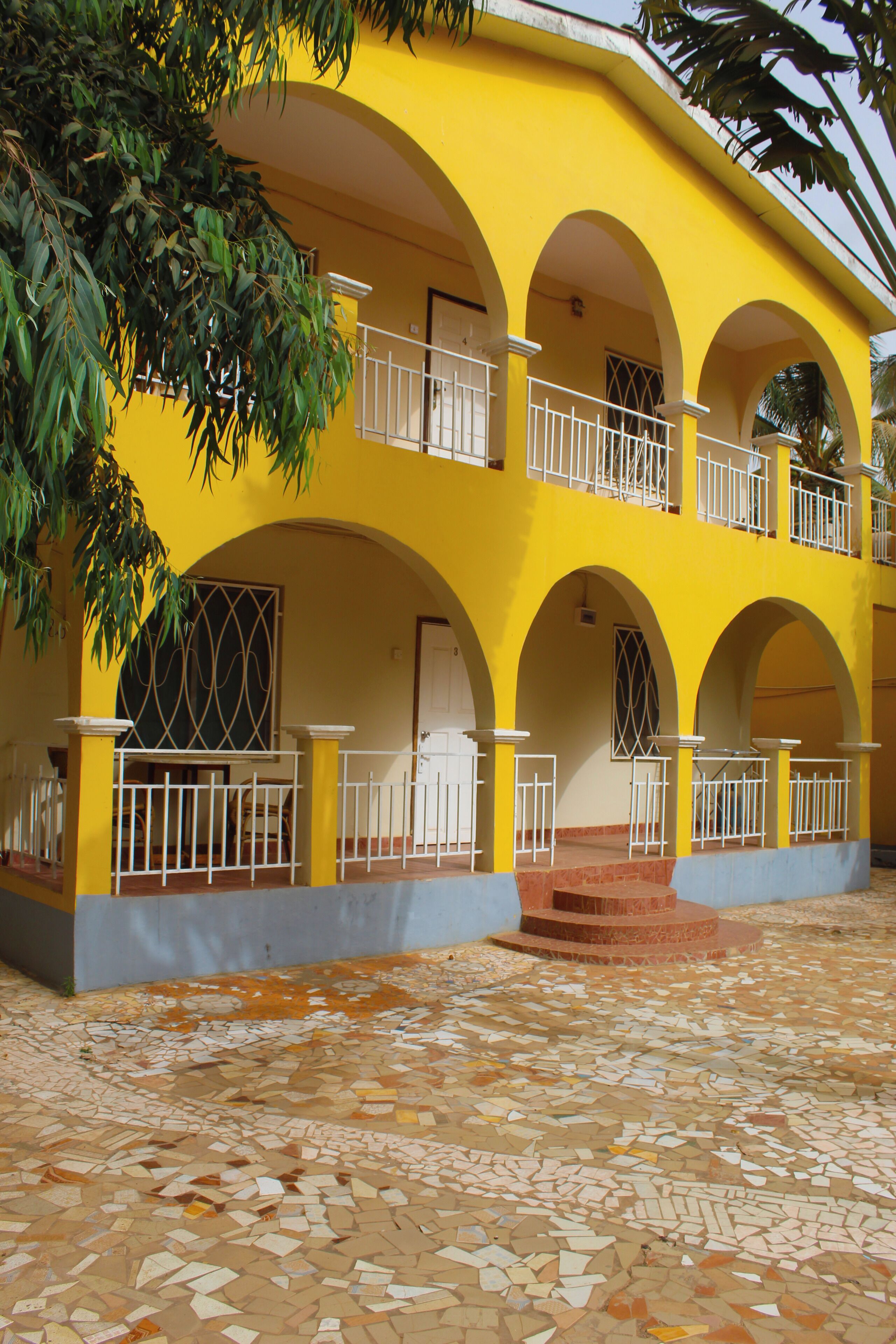 A yellow building with multiple arches and balconies.