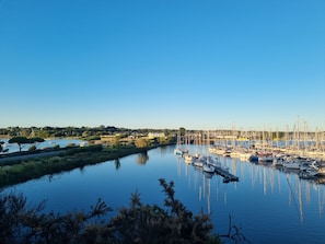 Uma marina com barcos atracados, águas calmas e céu limpo.