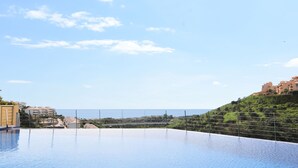 A rooftop infinity pool with a clear view of the ocean and a castle-like building in the background. - Guest favorite! Family apartment, terrace, spectacular views & pool near sea (Mijas costa)