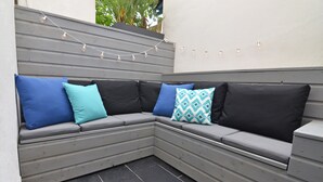 A corner seating area with grey cushions and patterned pillows. - Quiet 2 bedrooms apartment (Biarritz)