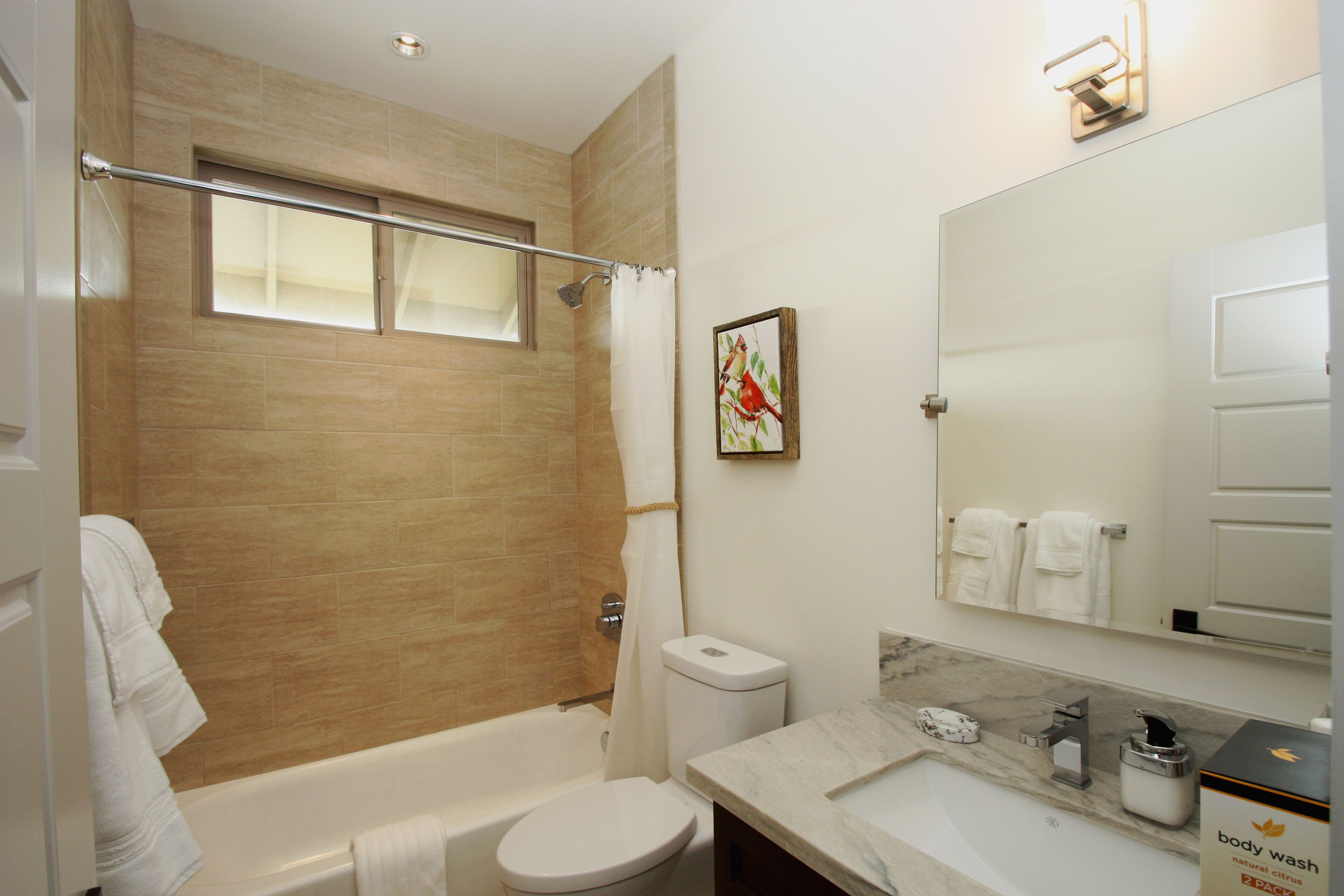A modern bathroom with a bathtub, toilet, and sink.