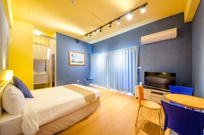 A hotel room with a bed, a desk, a television, and a window with curtains. - Garden Villa double RM (Yilan County)
