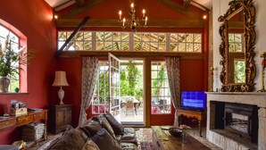 A cozy living room with a leather sofa, a fireplace, and a television.
