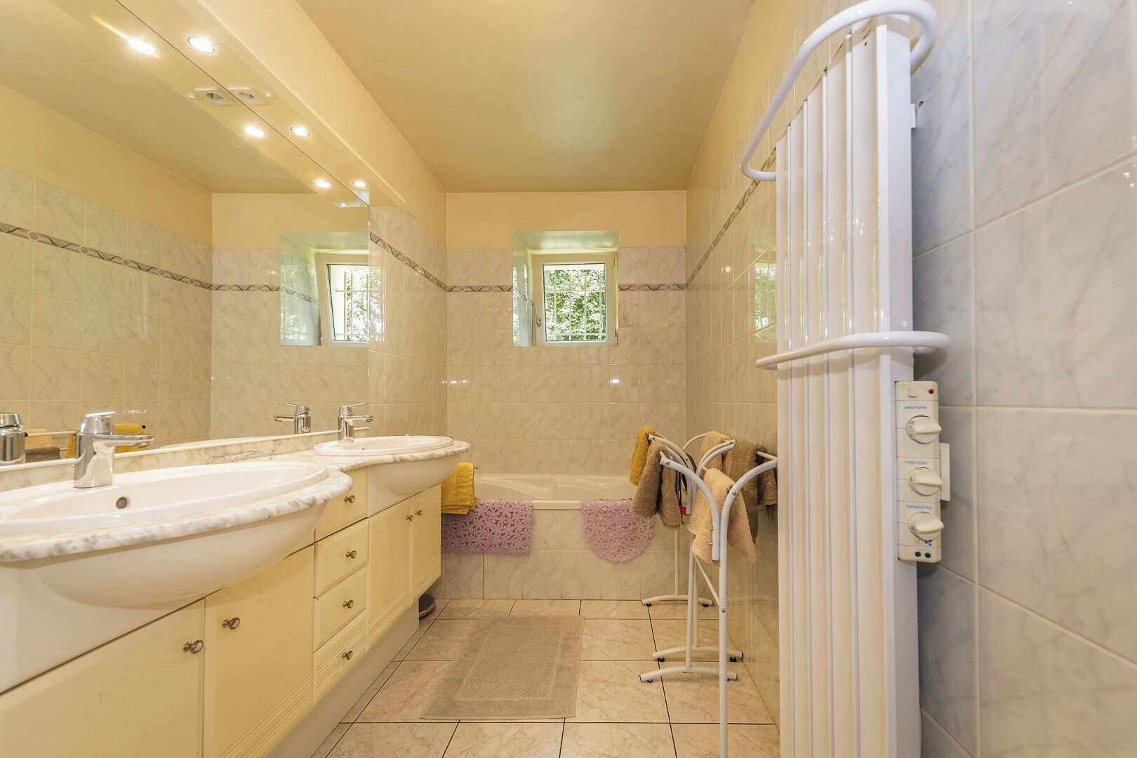 A modern bathroom with a large sink, vanity, and a walk-in shower.