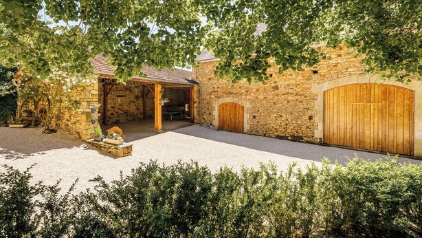 A stone building with a covered patio, a wooden door, and a gravel driveway. - Casalle, comfortable restored holiday home with private swimming pool (Montcléra)