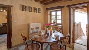 Ein rustikaler Essbereich mit Holztisch, Stühlen und einem Schild mit dem Aufdruck 'HOME'.