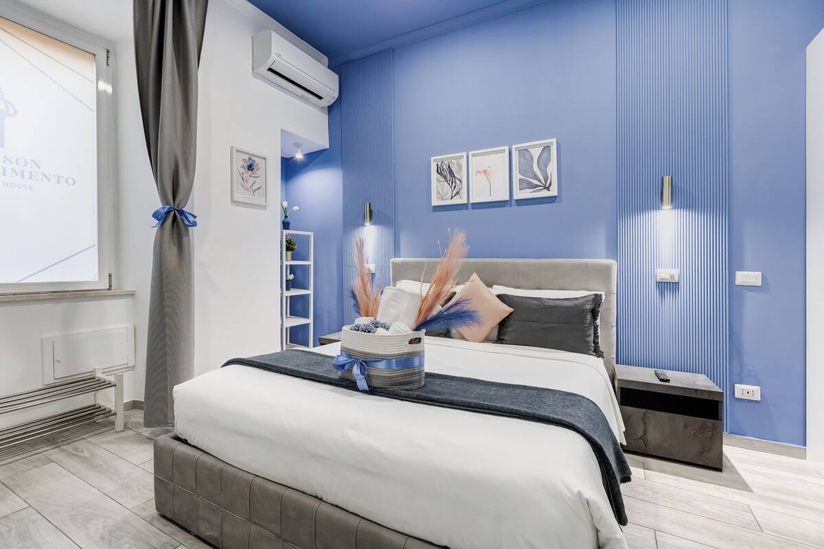 Un dormitorio moderno con cama, mesitas de noche y aire acondicionado instalado en la pared.