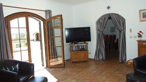 A living room with a TV, a wooden cabinet with DVDs, a coffee table, and two leather sofas. - Villa, Air-conditioned,  Heated Pool, Peaceful Location.
Beds 3,Bathrooms 3 (Quelfes. Olhao)