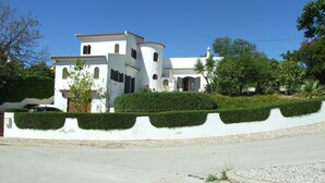A white building with a tiled roof, a small tower, and a well-maintained hedge in front. - Villa, Air-conditioned,  Heated Pool, Peaceful Location.
Beds 3,Bathrooms 3 (Quelfes. Olhao)
