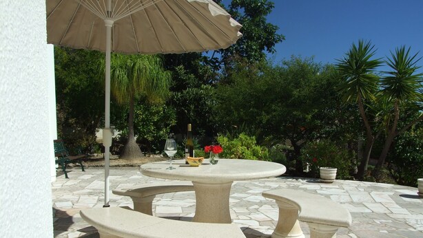 A patio with three stone tables and benches, a beige umbrella, and potted plants. - Villa, Air-conditioned,  Heated Pool, Peaceful Location.
Beds 3,Bathrooms 3 (Quelfes. Olhao)