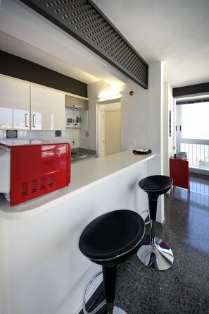 Een koelkast, een microgolfoven, kookgerei, borden en bestek