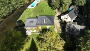 An aerial view of a property with a swimming pool, a large lawn, and a river. - Gite on the edge of the Arac in a green setting with swimming pool (Aleu)