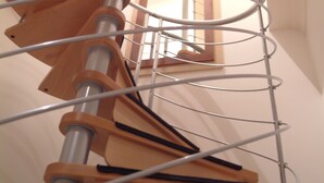 A spiral staircase with wooden steps and metal railings. - Cuirt na Coiribe 4 bedroom Apartment (sleeps 5) (Galway)