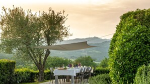 An outdoor dining area with a table set for six, surrounded by chairs, under a shade sail. - Beautiful private villa for 20 people with WIFI, private pool, sauna, TV and panoramic view (Rapale)