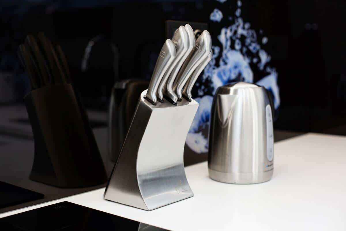 A modern kitchen with a knife block, a kettle, and a coffee maker.
