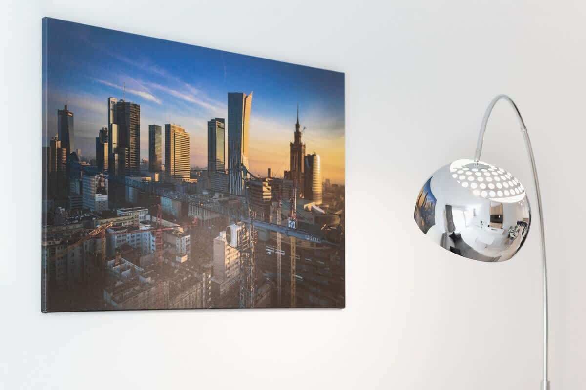 A cityscape painting with a modern lamp beside it.