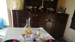 A breakfast setup with a table, food items, and drinks.