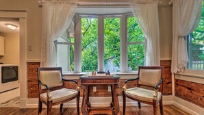 A room with a bay window, two wooden chairs, a small wooden table, and a television on the left. - Spacious & Updated 1920's HSNP Craftsmen Home (Hot Springs)