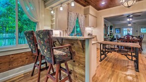 A dining area with a wooden table and chairs, a chandelier, and a view of the outdoors. - Spacious & Updated 1920's HSNP Craftsmen Home (Hot Springs)