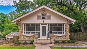 A two-story house with a stone facade, a front porch, and a garage. - Spacious & Updated 1920's HSNP Craftsmen Home (Hot Springs)