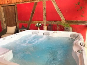 Ein Whirlpool mit Holzeinfassung und roten Wänden.