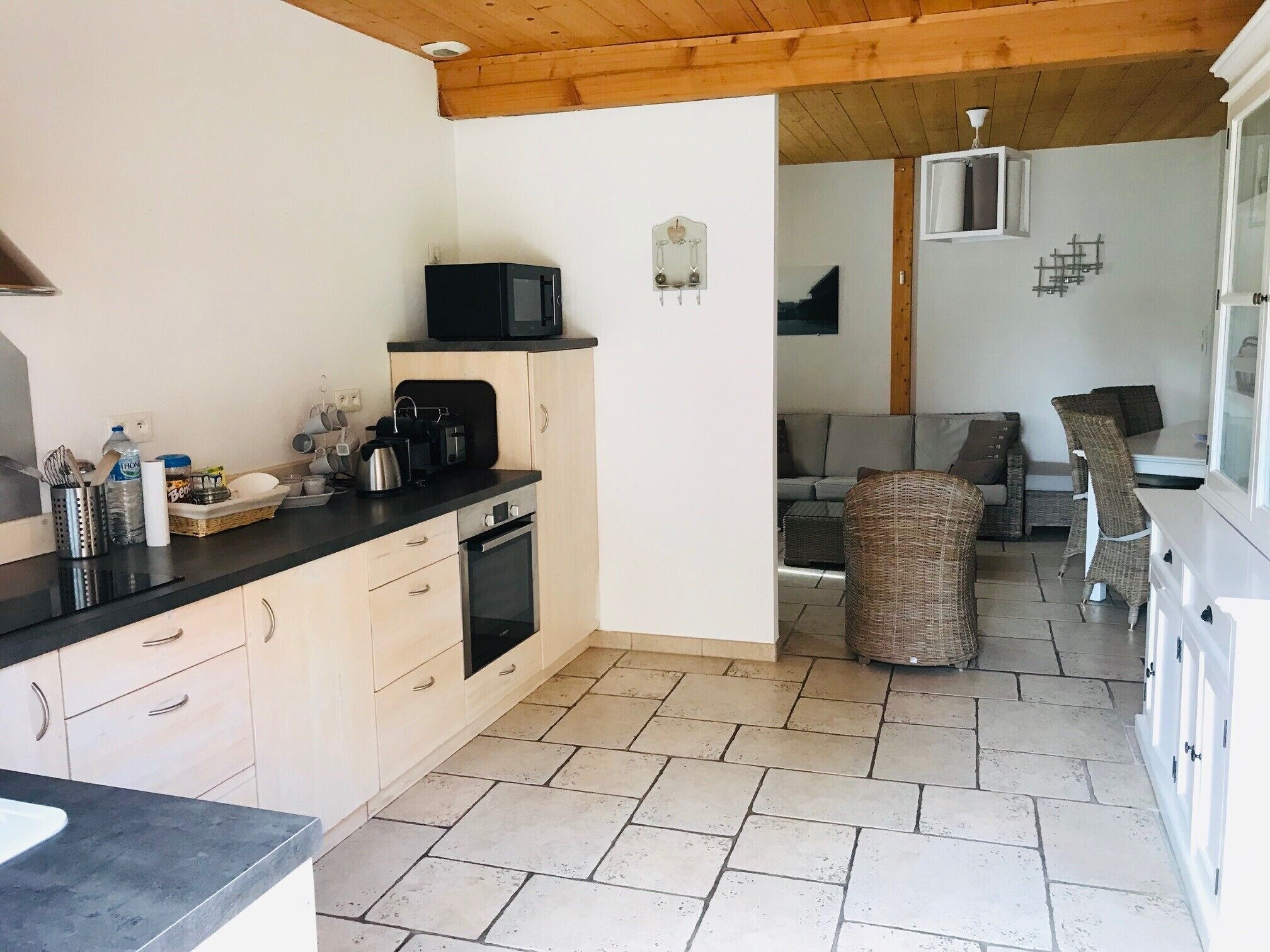 Eine kleine Küche mit Mikrowelle, Toaster und Wasserkocher auf der Arbeitsfläche, einem Spülbecken und Schränken.