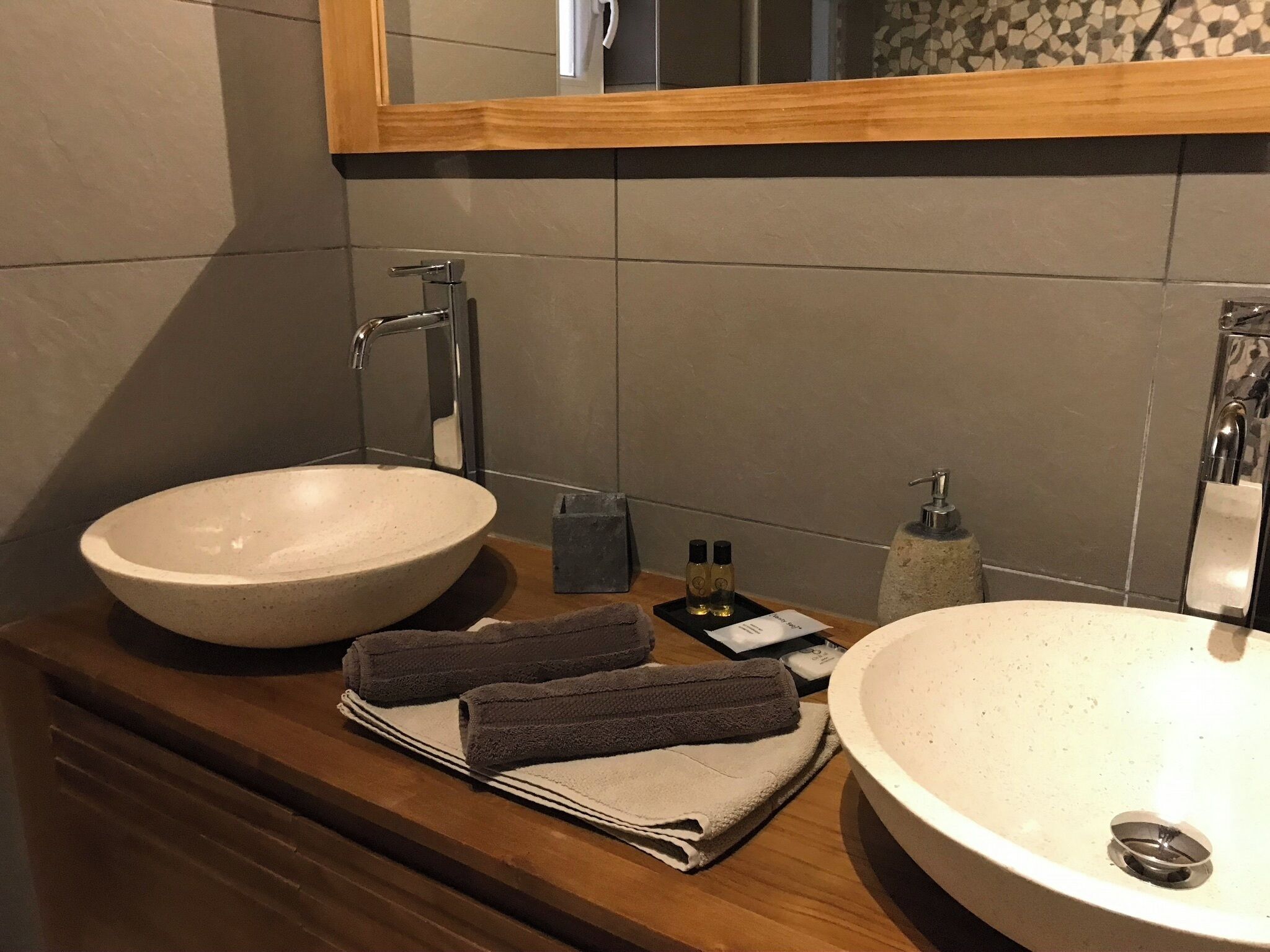 Een badkamer met twee wasbakken, een spiegel en handdoeken op het aanrecht.