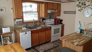 A compact kitchen with wooden cabinets, a built-in oven, and a sink.