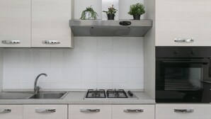A modern kitchen with a stainless steel sink, gas stove, and built-in oven. - N050 - Numana, three-room apartment in the center with porch and parking space (Numana)