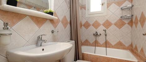 A bathroom with a sink, toilet, and bathtub.