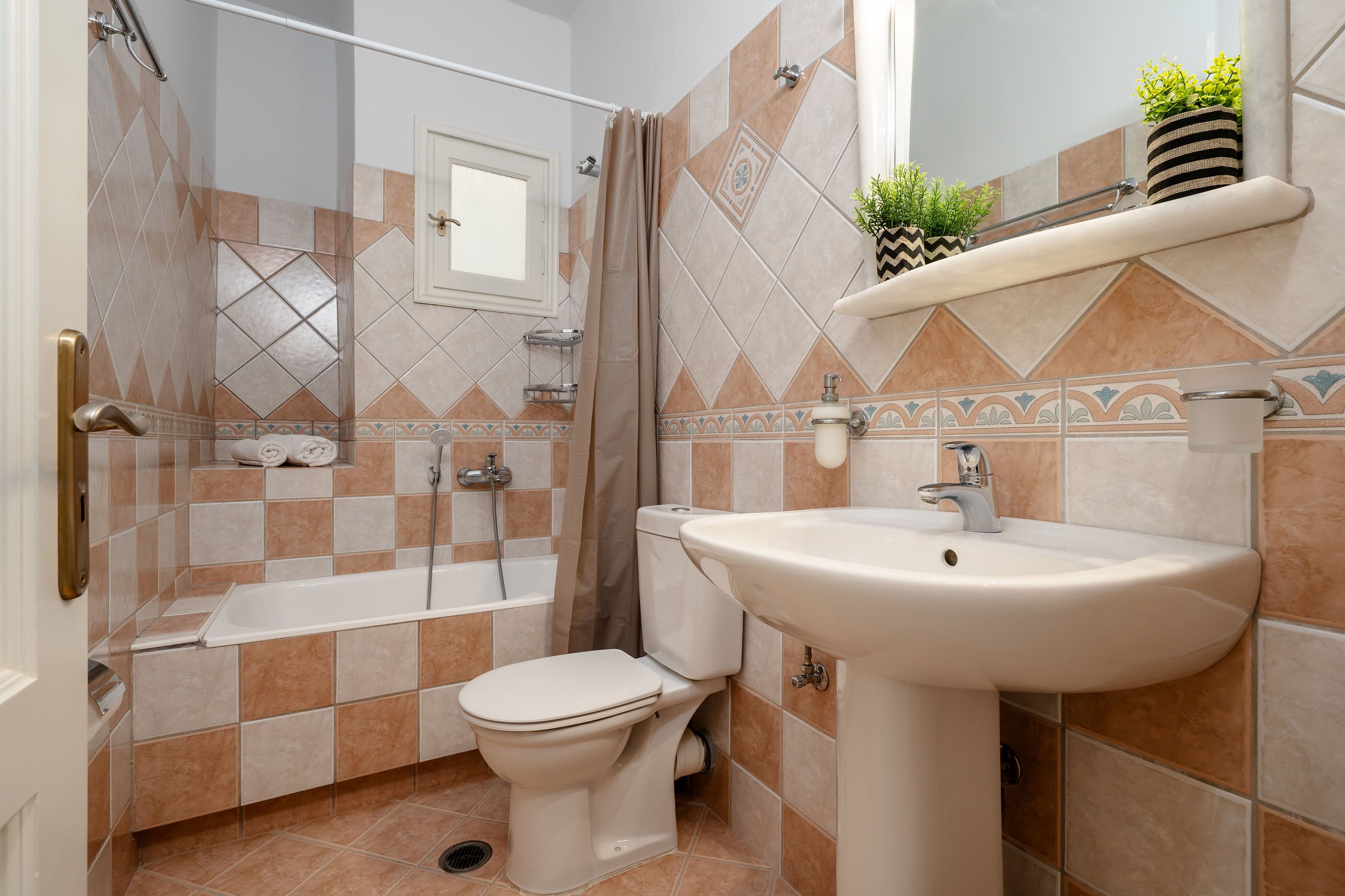 A bathroom with a bathtub, toilet, and sink.