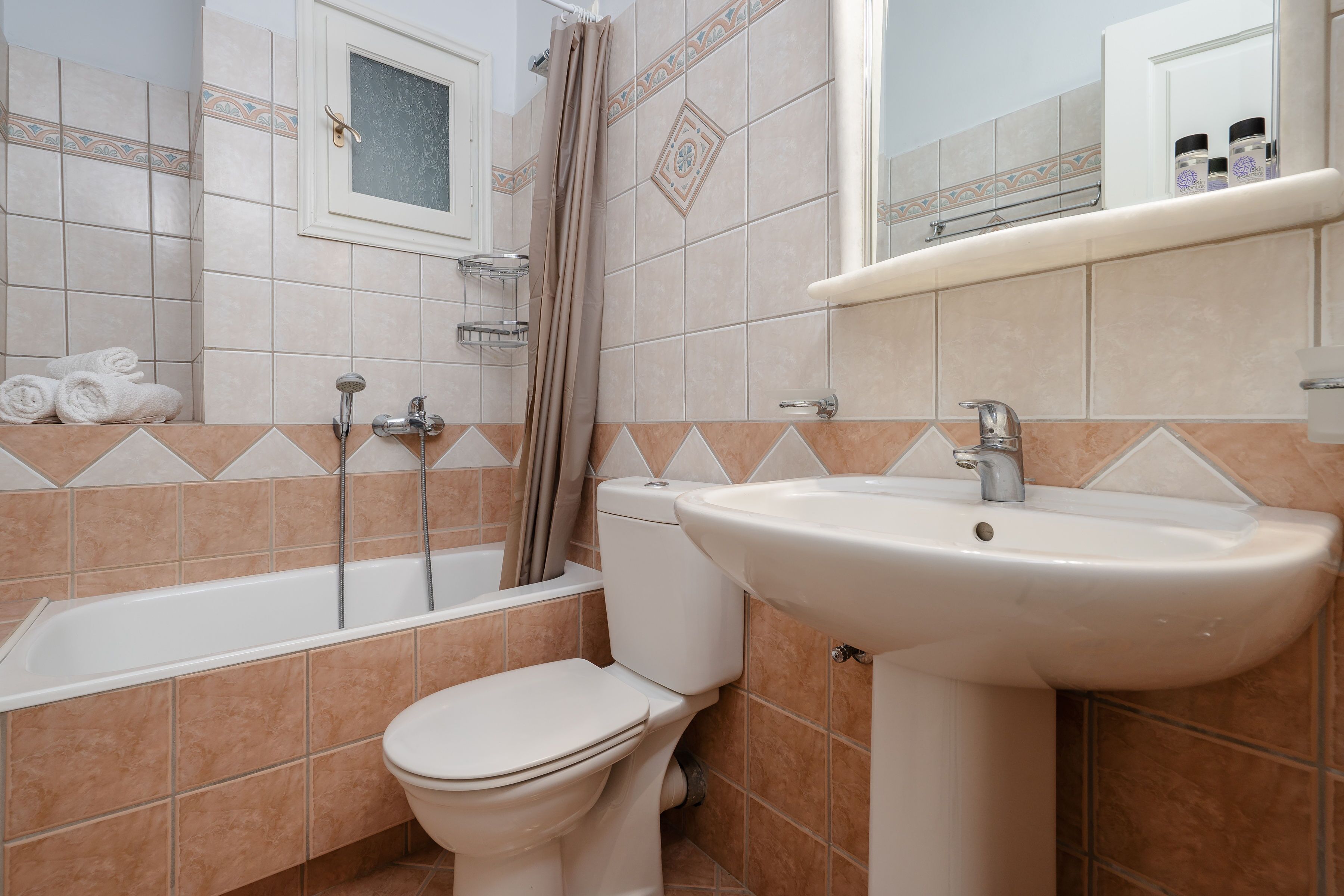 A bathroom with a bathtub, toilet, sink, and a shower curtain.