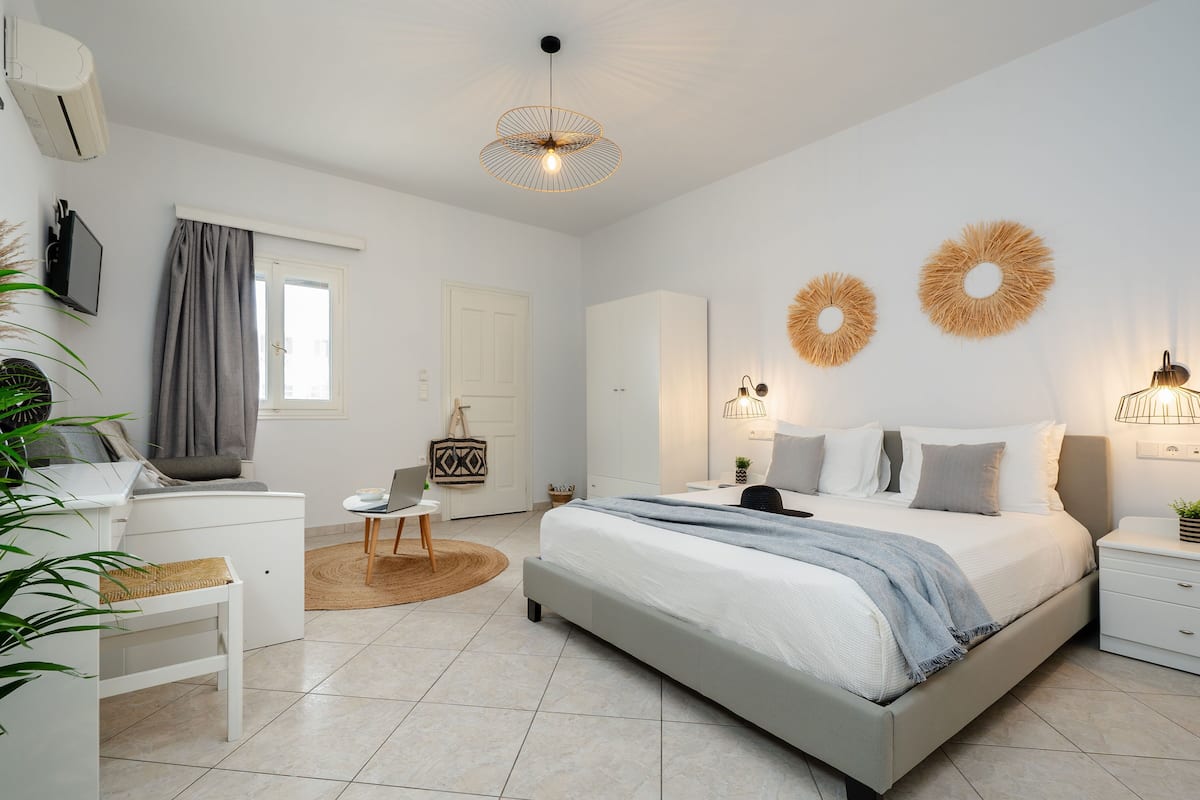 A modern bedroom with a bed, bedside tables, a desk, and a chair.