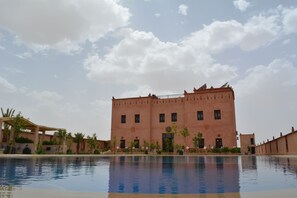 Una piscina al aire libre, sombrillas, tumbonas